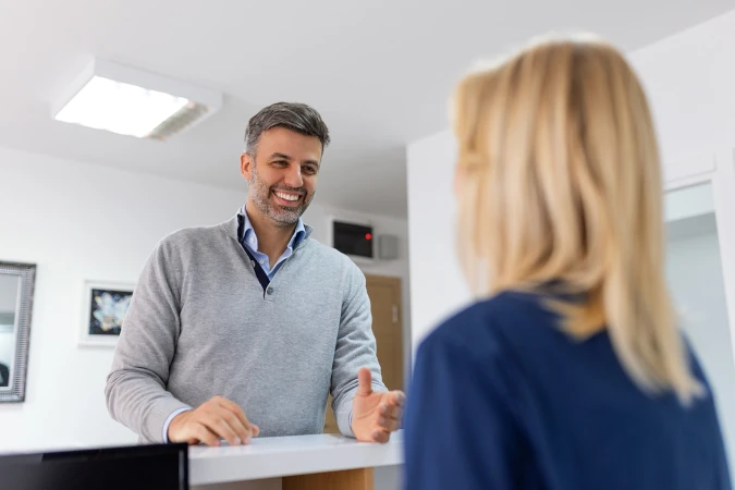 a man making an enquiry at a reception desk