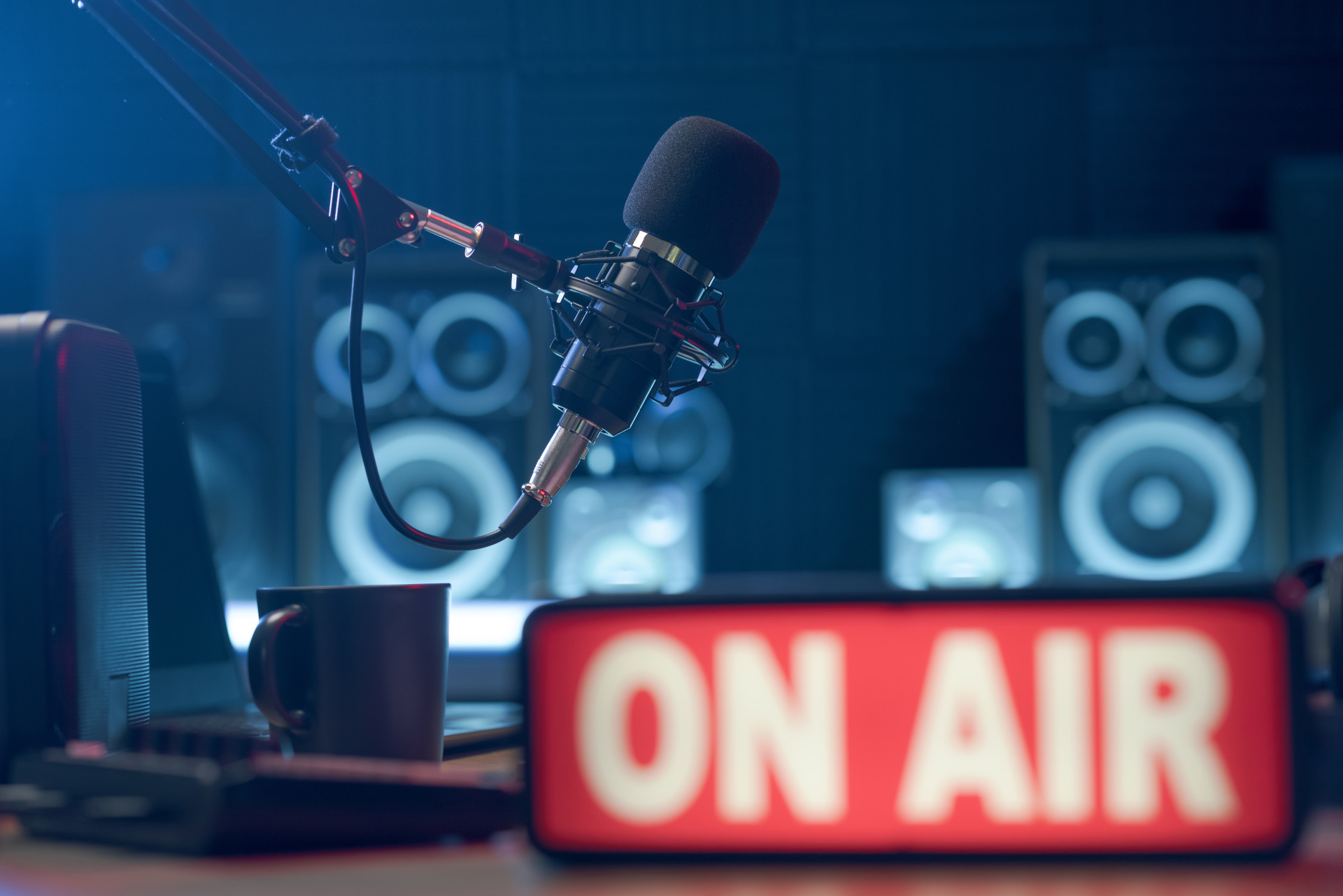 
                A microphone and audio equipment in a radio studio
              