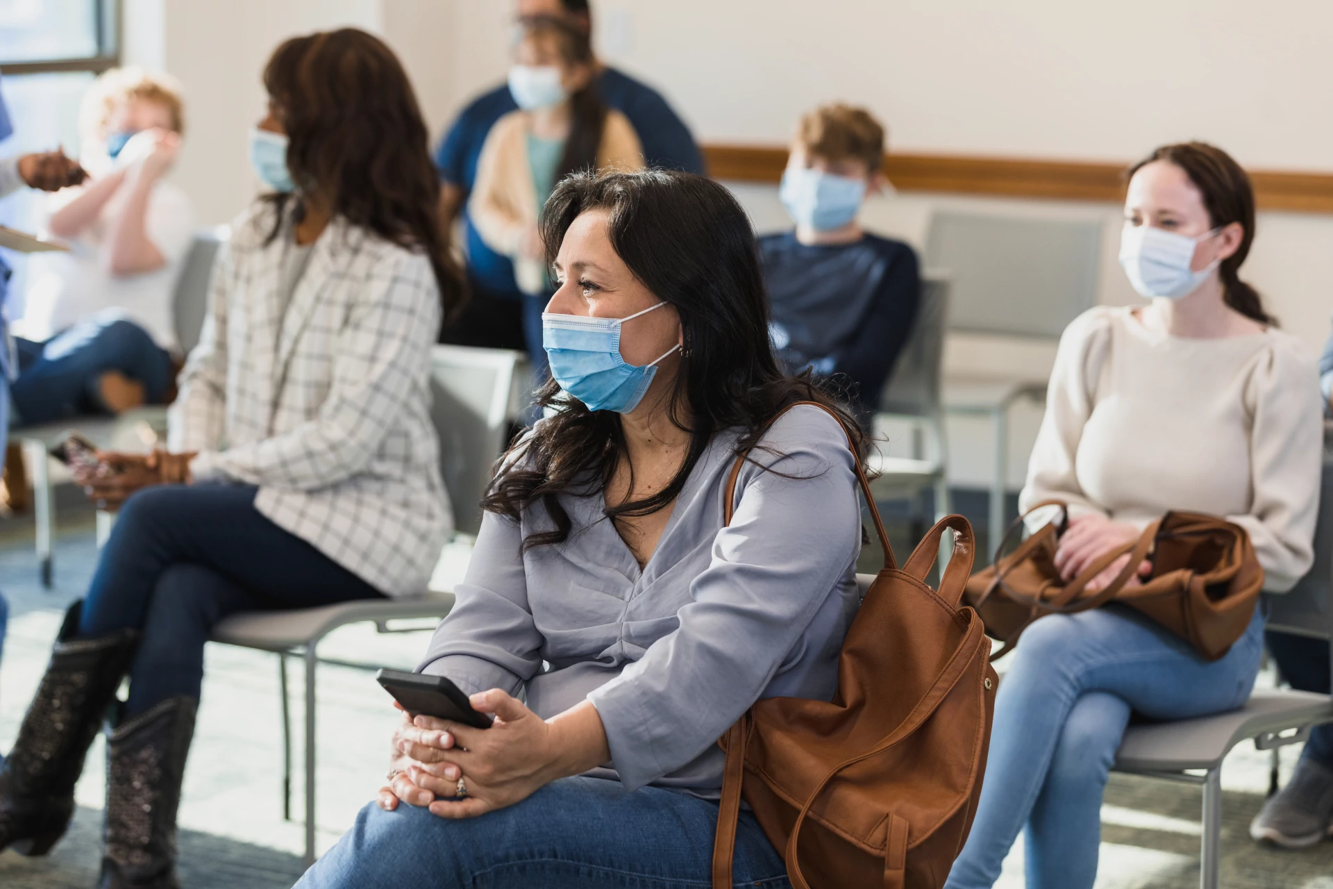 
                a group of patients wearing masks in a waiting room
              